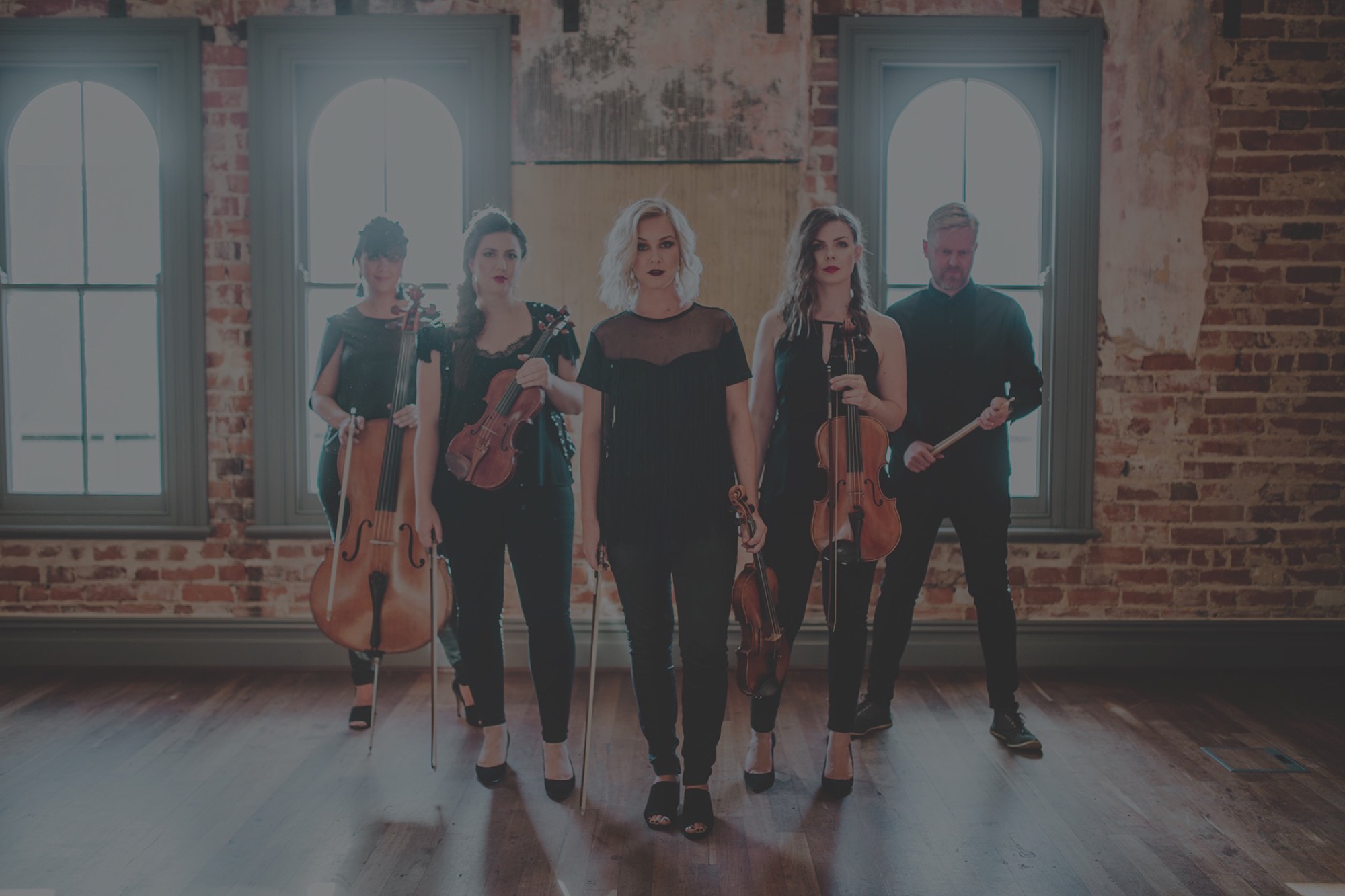 The Aquila string quartet band lined up in a brick hall